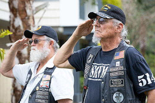 Two veterans salute during the opening ceremony of the Veterans Center of Excellence which houses the veterans Wall of Honor. 